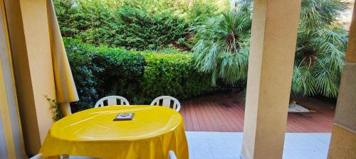 une table jaune et des chaises blanches sur une terrasse dans l'établissement T2 150m from the beach, à Fréjus