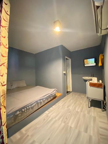 a bedroom with a bed and a blue wall at MD Kohlarn-Pattaya in Ko Larn