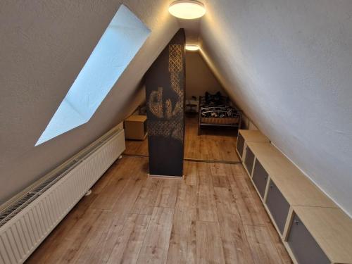 an attic with a staircase with a window and a wooden floor at Haus FayFay FerienMonteurApartment in Rüthen