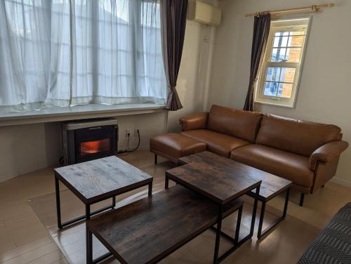 a living room with a couch and tables and a fireplace at 1棟貸し Villa YOU hokkaido date toya in Date