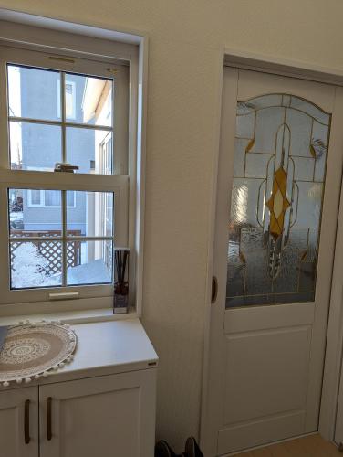 a kitchen with a door with a window and a chandelier at 1棟貸し Villa YOU hokkaido date toya in Date