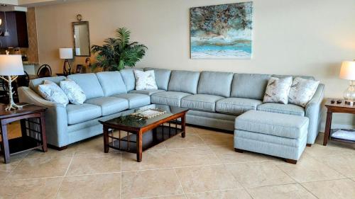 a living room with a blue couch and a table at Turquoise Place Condos in Orange Beach