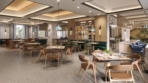 a restaurant with tables and chairs and a bar at Radisson Resort Khopoli in Khopoli