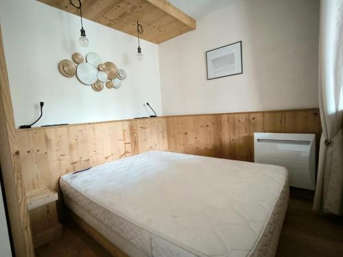 une chambre avec un lit blanc dans une pièce dans l'établissement Trés Jolie Appartment tout en bois, à Briançon