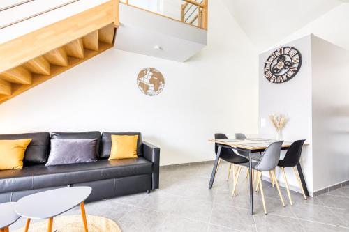 un salon avec un canapé noir et une table dans l'établissement Magnifique Duplex - CDG, à Tremblay-en-France