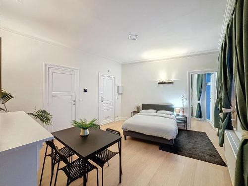 a bedroom with a bed and a table at Cosy Apartment Molière 2 in Brussels