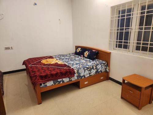 a small bed in a room with a window at Orchid Villa in Yercaud