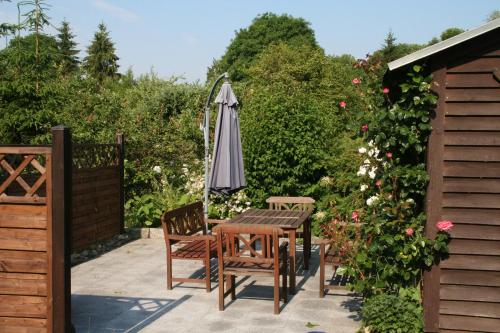 a table and chairs and an umbrella on a patio at Pension Villa Beer in Stralsund