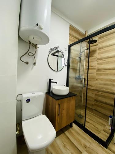 Un baño con inodoro, lavabo y ducha. en casa Felice, en Bitola