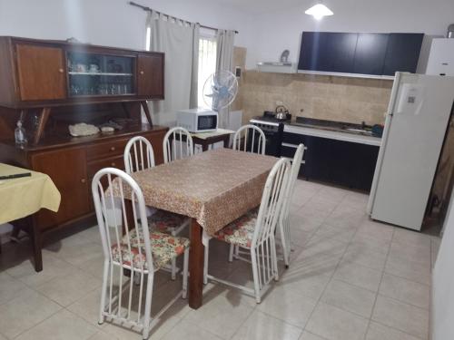 a kitchen with a table and chairs and a refrigerator at Aires de San Antonio in San Antonio de Arredondo