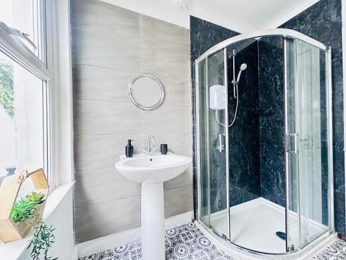 a bathroom with a sink and a shower at Lovey 6 Bed House Uplands Swansea - Perfect for Families and Contractors in Sketty