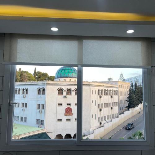a window with a view of a large building at Le confort absolu à 10 mn du cœur d'Alger in Birmandreis