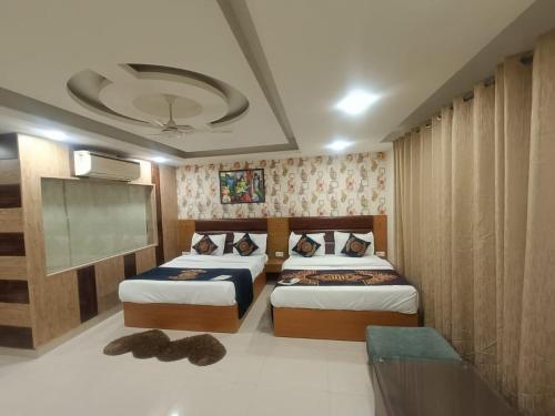 a hotel room with two beds and a tv at Hotel Grand Suites By D'Capitol Near IGI Airport in New Delhi