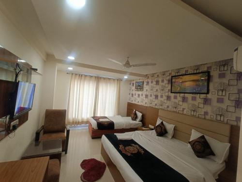 a hotel room with two beds and a television at Hotel Grand Suites By D'Capitol Near IGI Airport in New Delhi