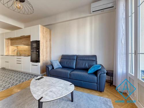 un salon avec un canapé bleu et une table dans l'établissement Golden Square, à Nice