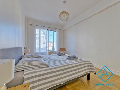 une chambre avec un lit avec une couverture rayée dans l'établissement Golden Square, à Nice