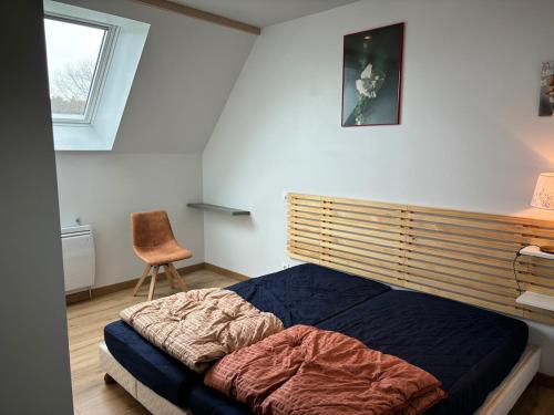 une chambre avec un lit, une chaise et une fenêtre dans l'établissement Gîtes entre 2 lacs, à Perret-Dessous