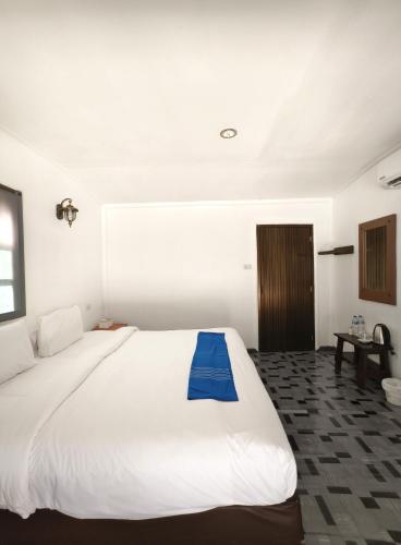 a bedroom with a large white bed with a blue blanket on it at Long Beach Club Krabi in Ao Nang Beach