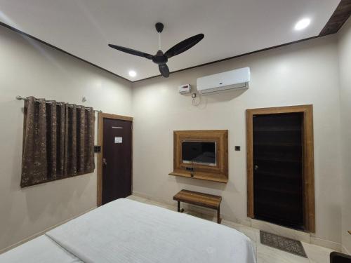 ジャバルプルにあるHotel Onyx Inn Zero Degreeのベッドと天井扇風機のある寝室