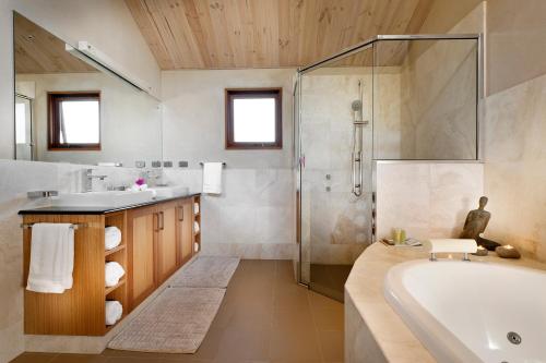 a bathroom with a tub and a shower and a sink at Aiyana Retreat in Denmark