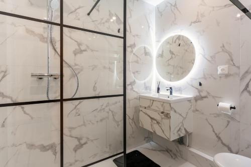 une salle de bain blanche avec une douche et un lavabo dans l'établissement Strasbourg centre logement cosy, à Strasbourg