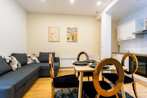 un salon avec un canapé, une table et des chaises dans l'établissement Strasbourg centre logement cosy, à Strasbourg