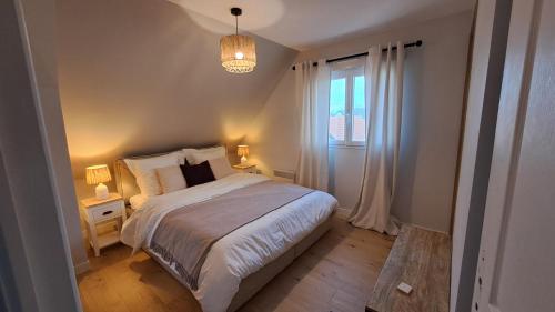 une petite chambre avec un lit et une fenêtre dans l'établissement Au bord de la mer, à Saint-Jean-de-la-Rivière