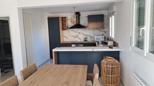 une cuisine avec une table, des chaises et un comptoir dans l'établissement Au bord de la mer, à Saint-Jean-de-la-Rivière