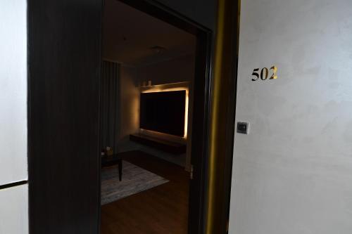 a hallway with a television and a door to a room at Palazzo hotel in Kuwait