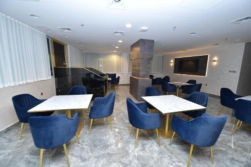 a room with tables and chairs and a tv at Palazzo hotel in Kuwait
