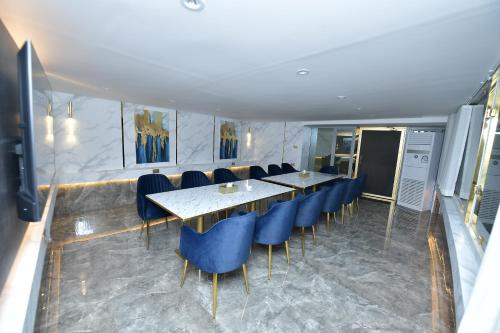 a dining room with a table and blue chairs at Palazzo hotel in Kuwait