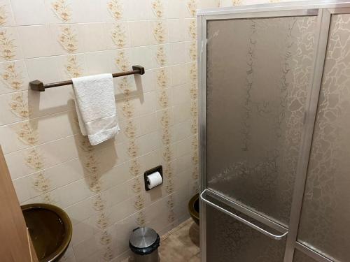 ein Bad mit einer Dusche, einem WC und einem Handtuch in der Unterkunft Casa temporada Angra e Paraty in Angra dos Reis