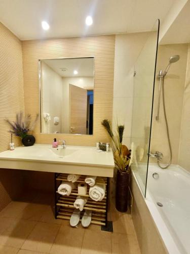 a bathroom with a sink and a tub and a mirror at Eduard Elegance Rin Studios in Bucharest