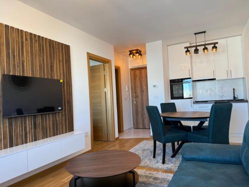 a living room with a television and a dining room table at Apartman Nikola in Zlatibor