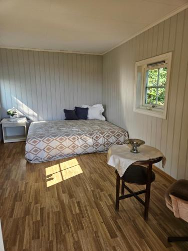 Un dormitorio con una cama, una mesa y una silla. en Utsikten Bjerkøya, en Holmestrand