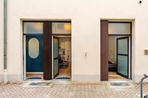un groupe de portes en verre sur un bâtiment blanc dans l'établissement Strasbourg centre logement cosy, à Strasbourg