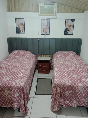 two beds sitting next to each other in a room at Cantinho do lar in Timbó