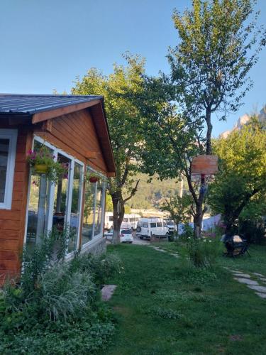 a house with a yard with trees and a parking lot at Bujtina Arlindi in Valbonë