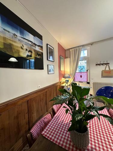 un salon avec une table et une plante en pot dans l'établissement La maison bleue, à Villerville