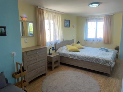 a bedroom with a bed with yellow pillows on it at Къща за гости ЕЛЕНИ in Sozopol