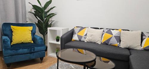 a living room with a couch and a table and a chair at Glebe House - 2 Bedroom Luxury House with 4 Beds, Free Private Parking with Access to City Centre, and Near the Motorway in Moston