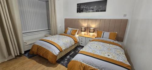 two beds in a small room with two at Glebe House - 2 Bedroom Luxury House with 4 Beds, Free Private Parking with Access to City Centre, and Near the Motorway in Moston