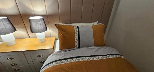 a bedroom with a bed and a desk with two lamps at Glebe House - 2 Bedroom Luxury House with 4 Beds, Free Private Parking with Access to City Centre, and Near the Motorway in Moston