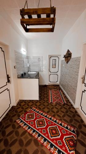 a room with a kitchen with a rug on the floor at Petra Wooden House in Wadi Musa