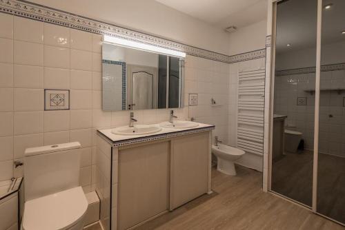 La salle de bains est pourvue de 2 lavabos, de toilettes et d'une douche. dans l'établissement Maison Bompas 6 personnes piscine et jacuzzi, à Bompas
