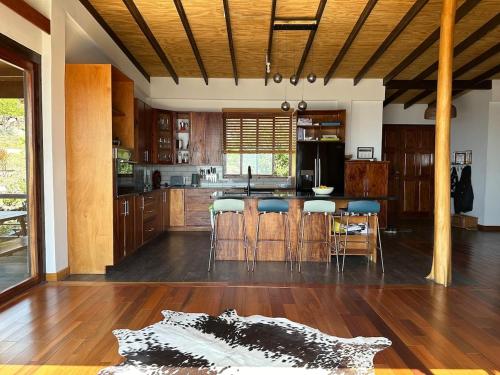 Una cocina con gabinetes de madera y una mesa y sillas. en Paradise Factory St Lucia, en Choiseul