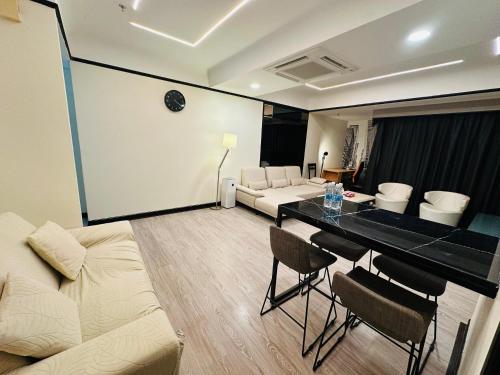 a living room with a couch and a table with chairs at The Times Square By Family Suites in Kuala Lumpur