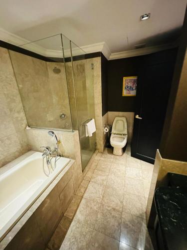 a bathroom with a bath tub and a toilet at The Times Square By Family Suites in Kuala Lumpur