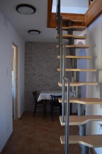 a spiral staircase in a dining room with a table at Tücsi lak in Szigetszentmárton