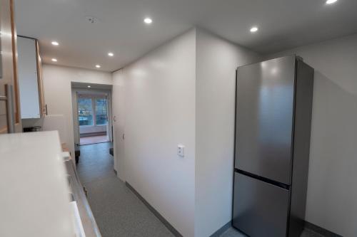 a kitchen with a refrigerator in a white wall at Danderyd - Eget hus med 12 min till STHLM city in Danderyd